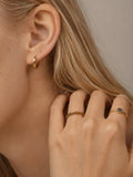 Knife edge huggie hoops styled with gemstone rings