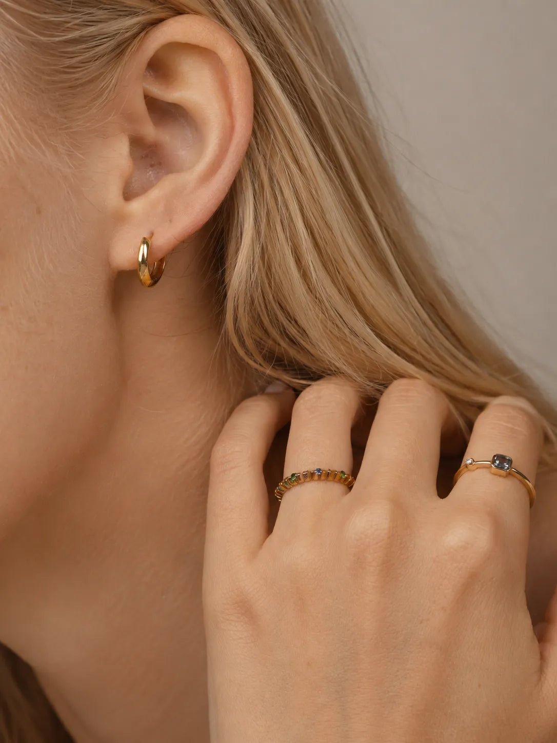 Knife edge huggie hoops styled with gemstone rings