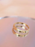three star gold diamond ring accents on a soft pink background by PETRALO