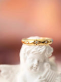 14k star diamond Gold ring with star designs on a white statue against a blurred background